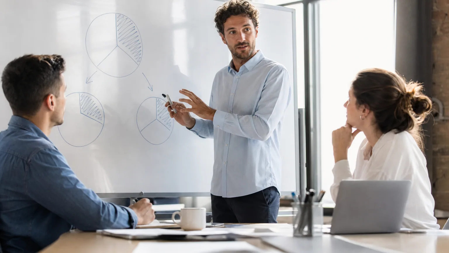 Dirigeant de startup expliquant un plan de BSPCE à ses salariés autour d'un tableau blanc