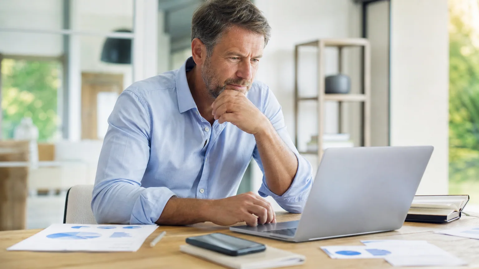 Auto-entrepreneur consultant une facture électronique sur son ordinateur portable dans son bureau