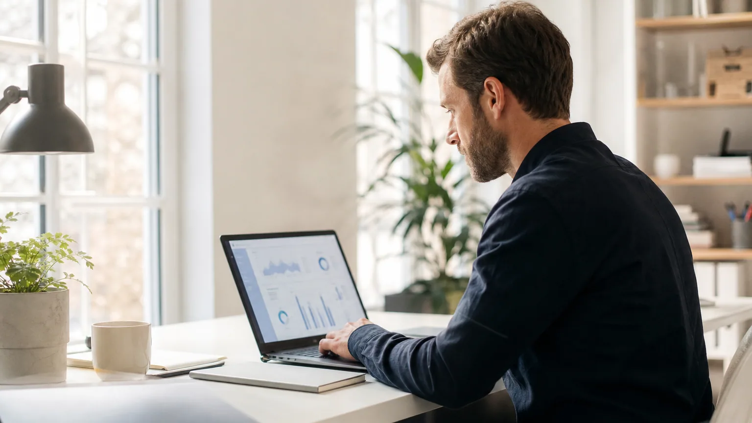 Entrepreneur solo travaillant sur son ordinateur dans un bureau lumineux, lancement d'un micro-SaaS