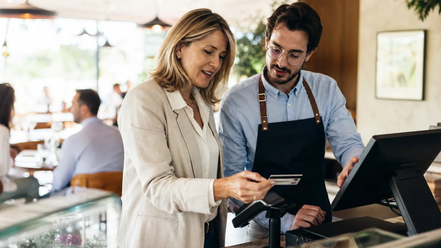 Dirigeante de petite entreprise et salarié consultant une carte de titre-restaurant